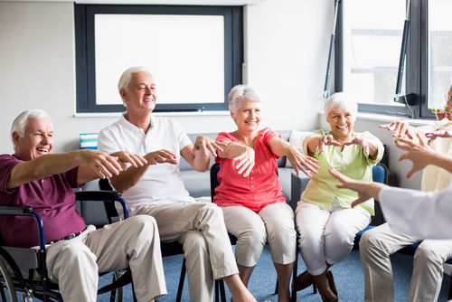 Seniors doing exercises sitting