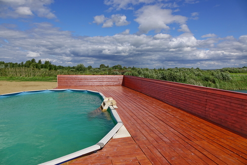 above ground frame swimming pool with wooden patio deck
